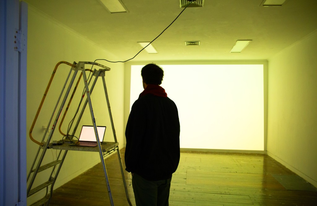 The Weather Room — gallery space during install, projector above door, ladder and laptops