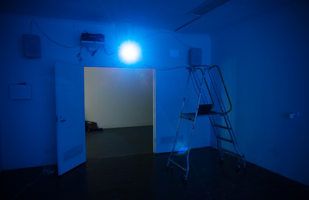 The Weather Room — visitor facing a large illuminated screen, green-amber wash over the room