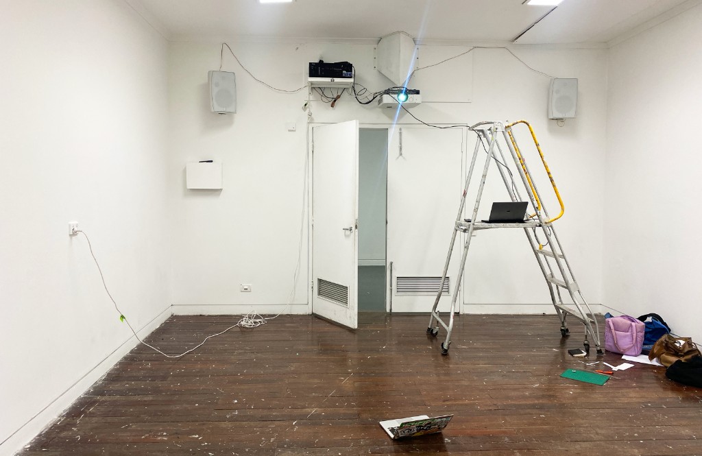 The Weather Room — doorway view into blue-lit room with projection and ladder